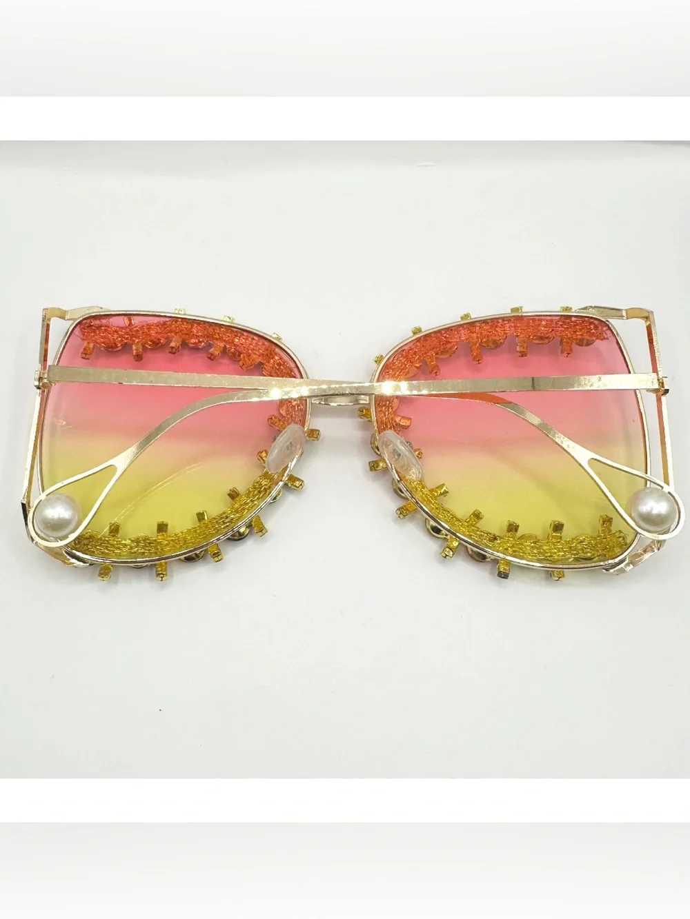 Oversized gold-frame party sunglasses featuring vibrant pink-to-yellow gradient